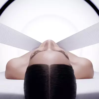 Woman's face lifted by white bands, evoking the Replasty soothing bandage technology